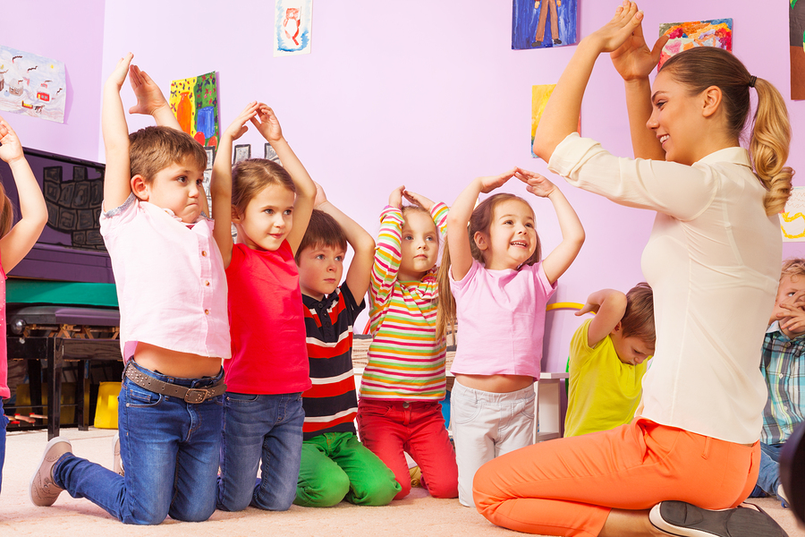 Group of kids repeat gesture after the teacher